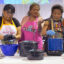 Tennile Lopez (left) shapes blue corn dough while Bertha Etsitty (right) explains the process of blue corn mush on Nov. 25 at the food gathering summit held by Diné College's Land Grant Office. Credit: Noel Lyn Smith/Inside Climate News