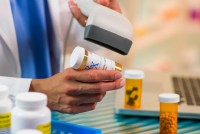 A close-up of a pharmacist scanning a prescription.