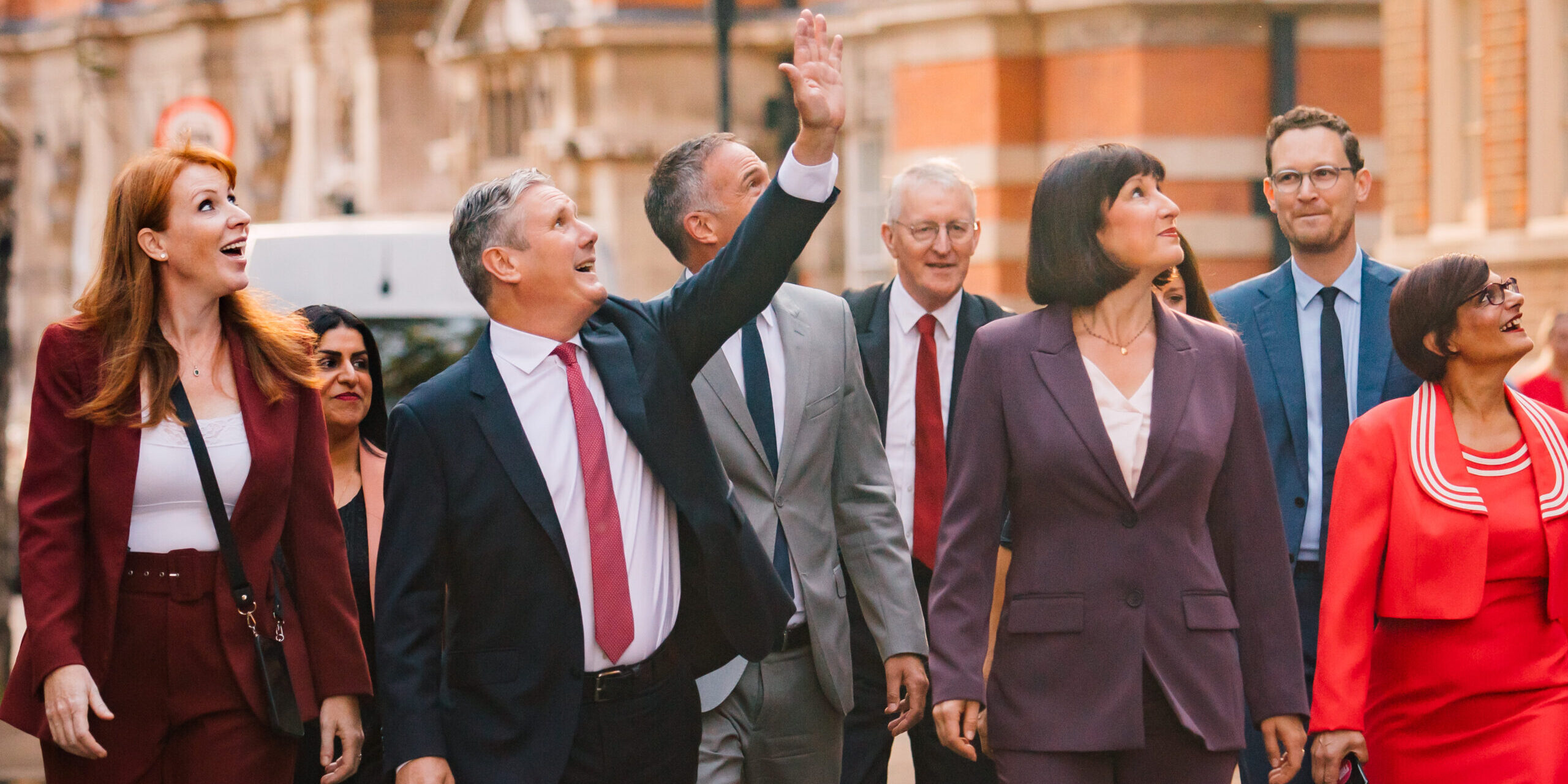 Keir Starmer and members of the Shadow Cabinet looking up and to the left to wave to someone out of shot