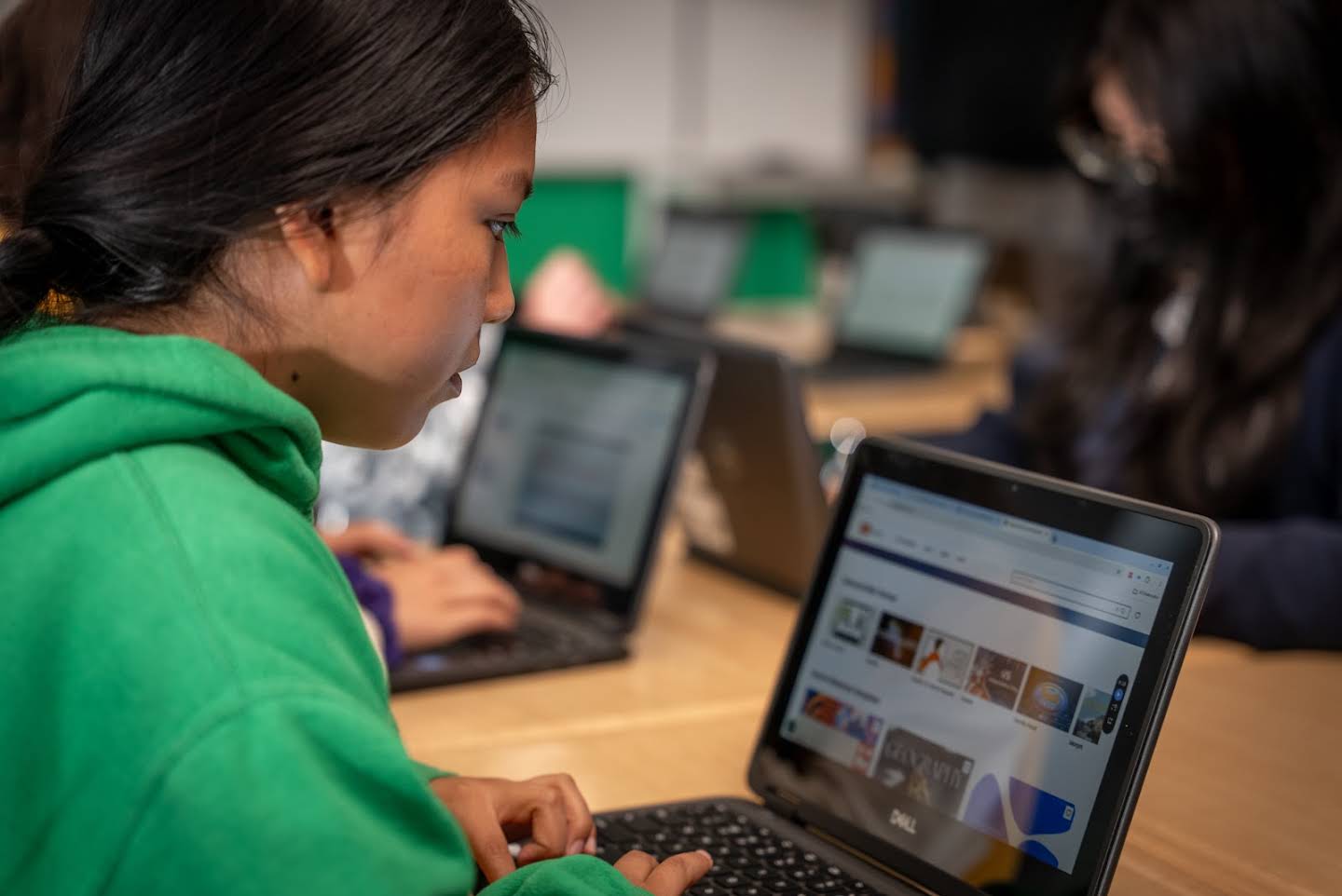 A student on a laptop is designing a presentation.