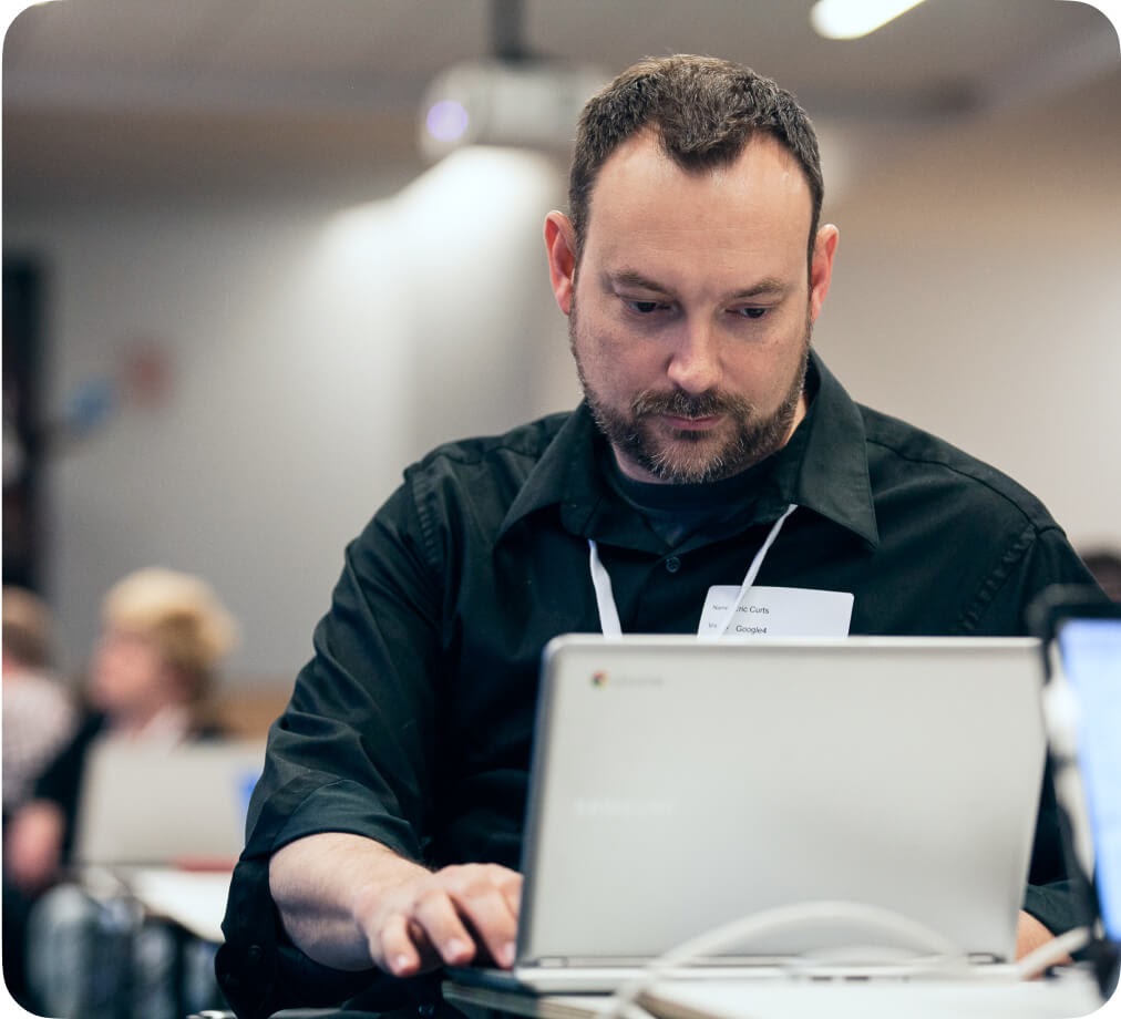 An IT administrator is focused in front of a laptop.