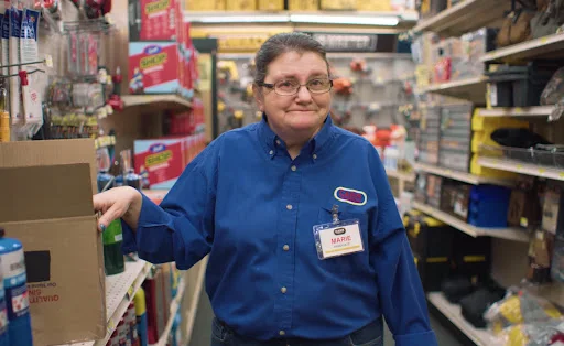 Video still of a woman working in a shop.