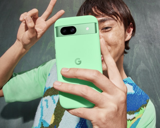 Person talking a selfie with Pixel 8a in Aloe color.