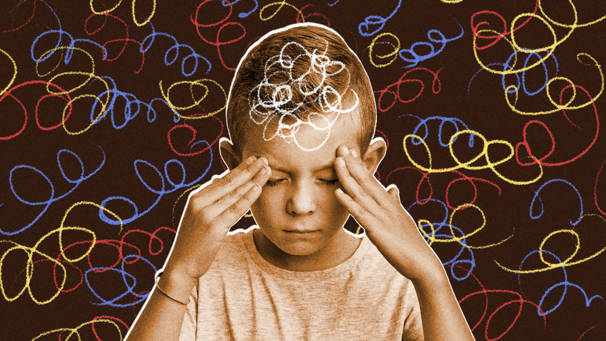 A boy with his fingers to his temples surrounded by an abstract background covered in primary colored crayon spirals