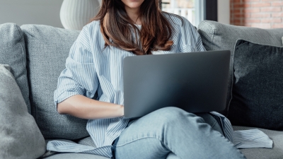 person looking at laptop on couch 