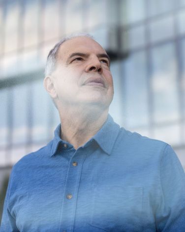 a man in a blue shirt looks up at the sky