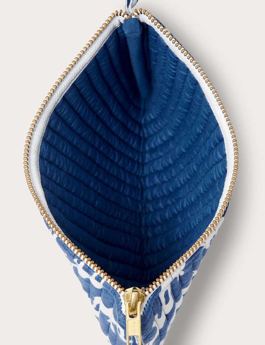 Quilted clutch bag with Elephant Palace Blue print, featuring a gold zipper and blue quilted interior.