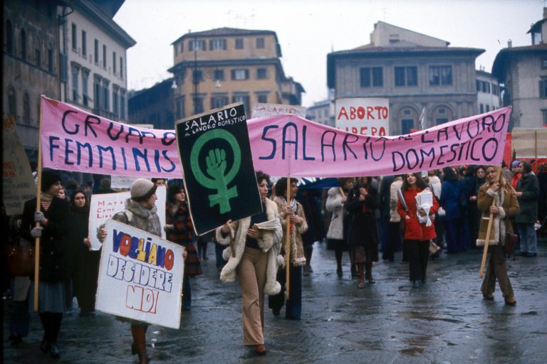 Mariarosa Dalla Costa (center) carries the green and black “Wages for Housework” sign.