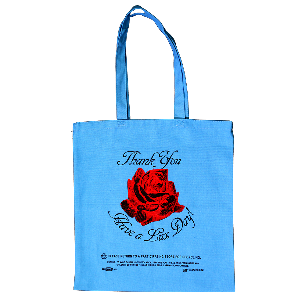 a flat scan of a blue canvas tote bag that says "Thank You, Have a Lux Day!" with a central red rose