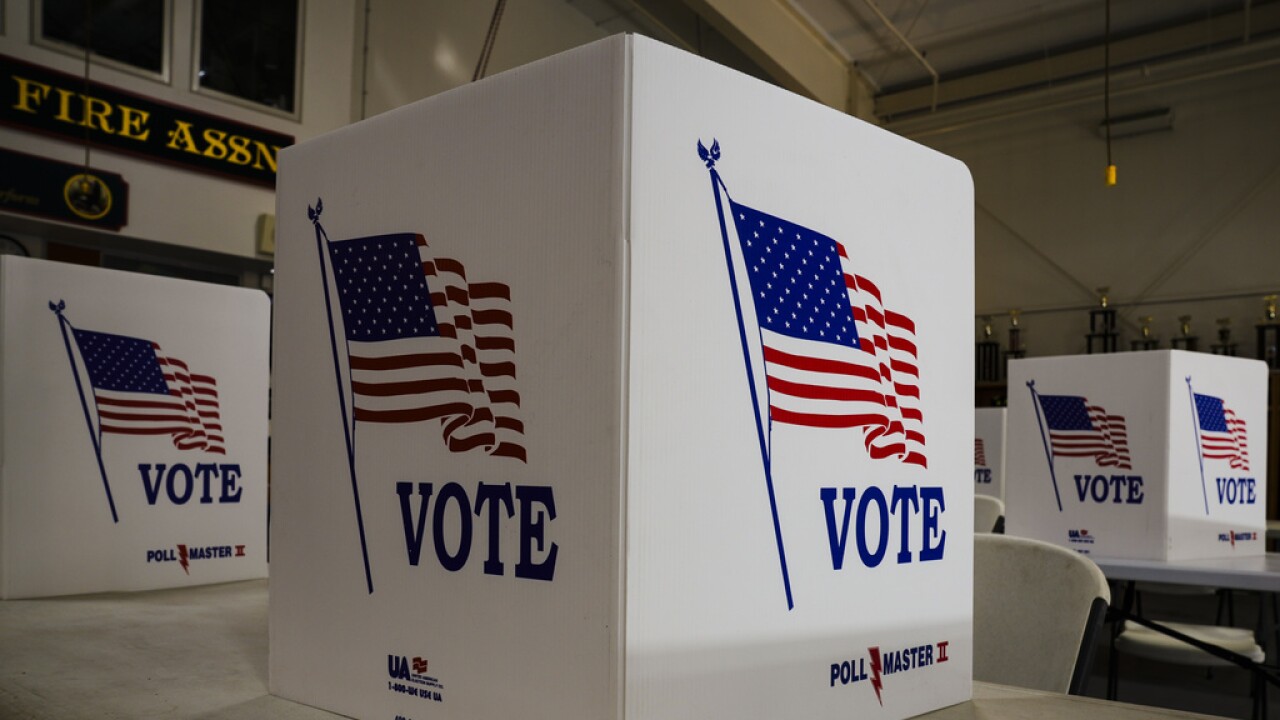 three american flags on display at a voting booth