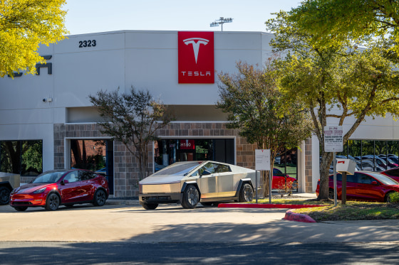 A Tesla Cybertruck is parked outside of a dealership