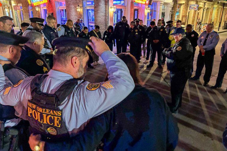 New Orleans police chaplain Ken DeSoto, center, leads other officers in prayer on Bourbon Street on Thursday, Jan. 2, 2025.