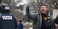 Russell Taylor, right, makes an obscene gesture, obscured by NBC News, at the Capitol on Jan. 6, 2021.