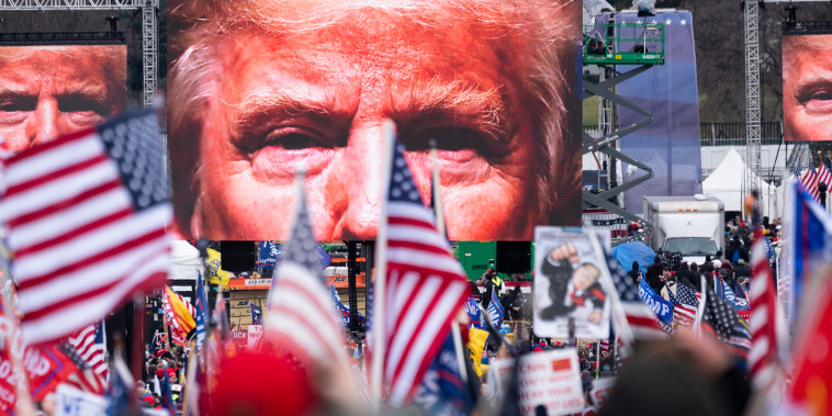 An image of President Donald Trump appears on video screens