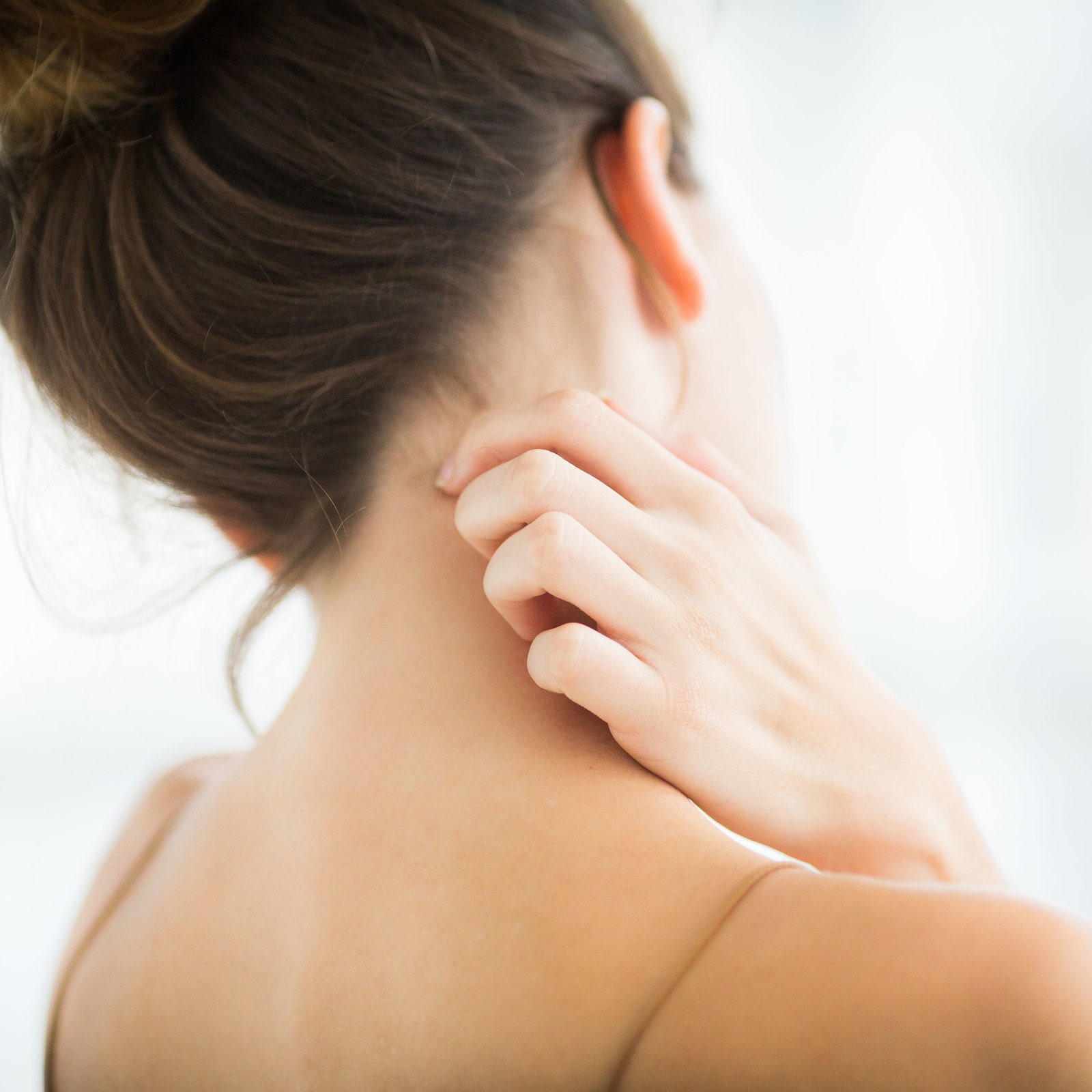Woman scratching back of neck