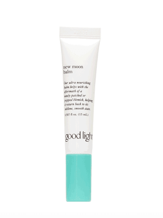 A small white tube of Good Light New Moon Balm with teal cap on white background