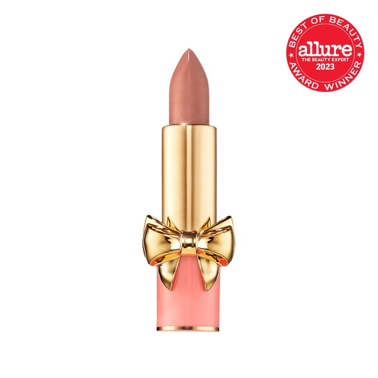 Pat McGrath Labs Satin Allure Lipstick peach and gold tube of nude lipstick with bow detail on white background with red...