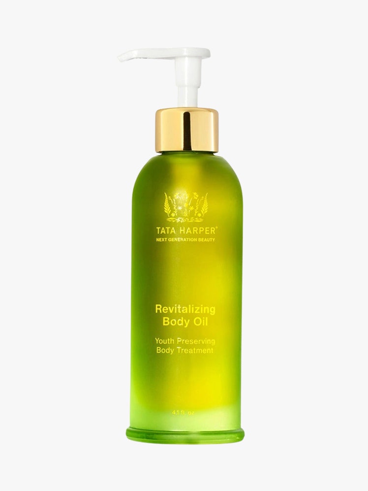 Revitalizing Body Oil green bottle with push down top on light grey background