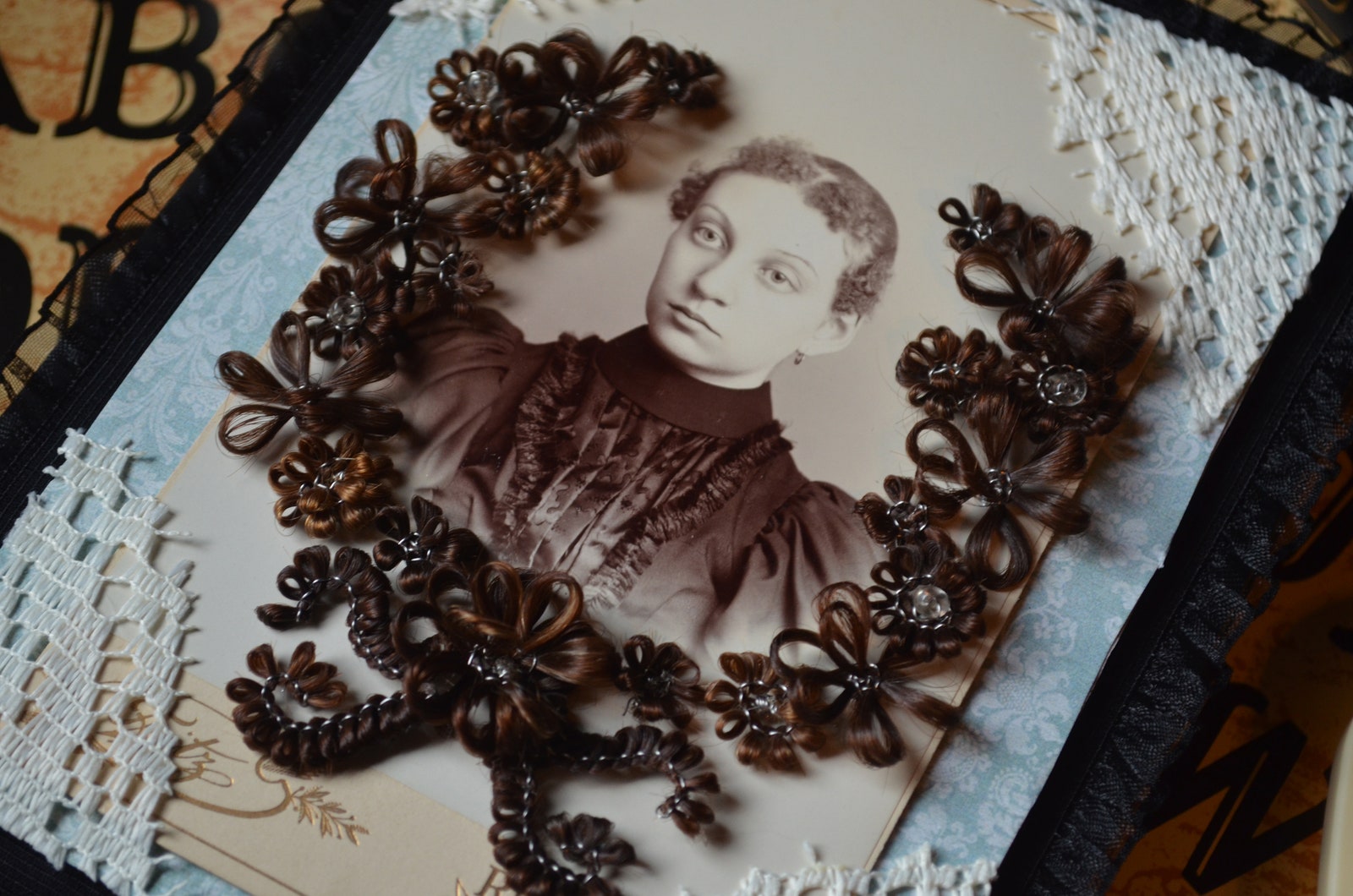a hairwork wreath by hallie schneck layered on on a vintage portrait photo