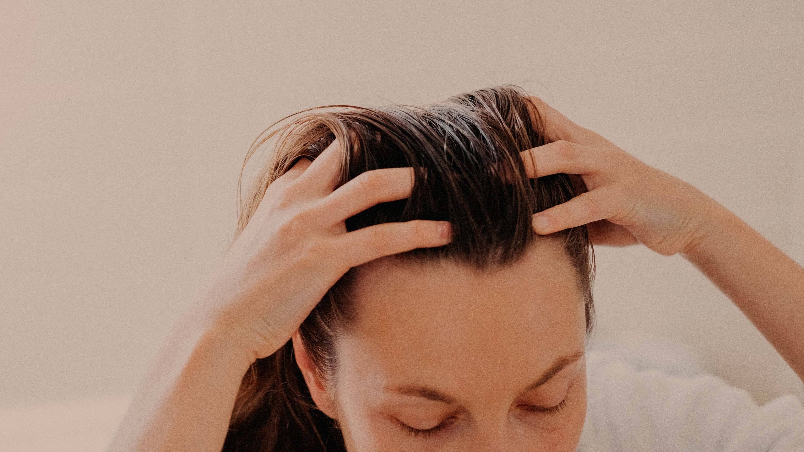 top of person's head with hands in hair
