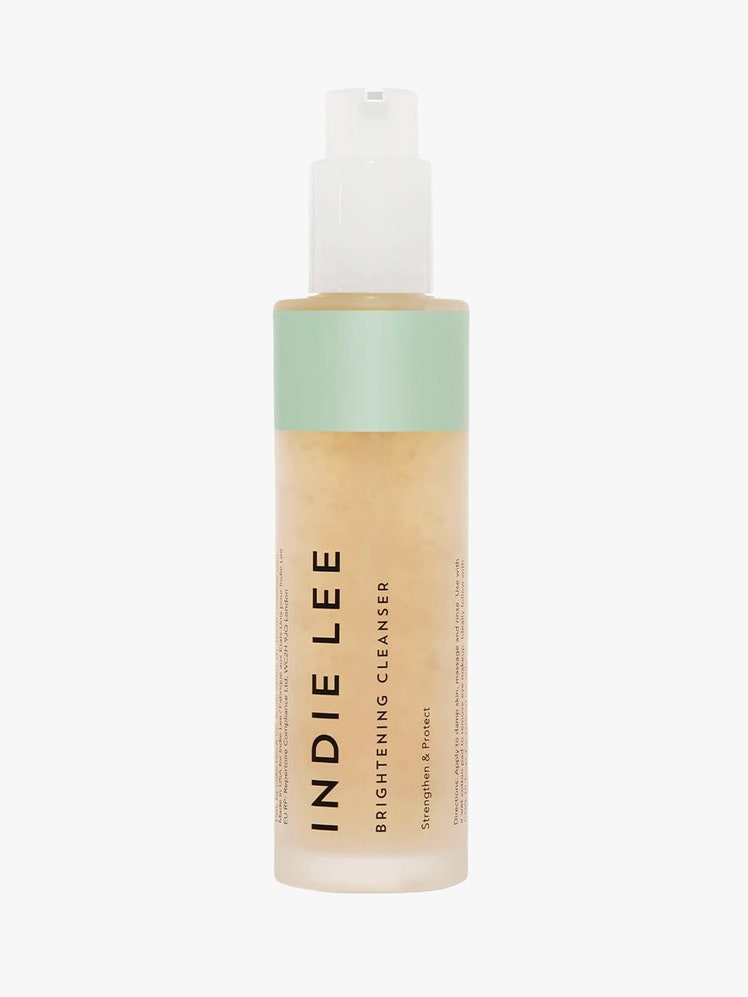 Indie Lee Brightening Cleanser in glass bottle with white pump on light grey background