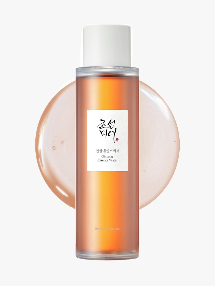 Beauty of Joseon Ginseng Essence Water in bottle with orange contents and swatch on gray background