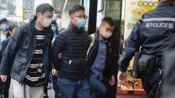 Editor of "Stand News" Patrick Lam, second from left, is arrested by police officers in Hong Kong, Wednesday, Dec. 29, 2021. Hong Kong police say they have arrested seveal current and former staff members of the online media company for conspiracy to publish a seditious publication. (AP Photo/Vincent Yu)