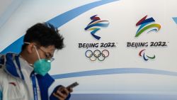 A man walks past Winter Olympics and Paralympics branding at the Main Press Centre on January 26 in Beijing, China.