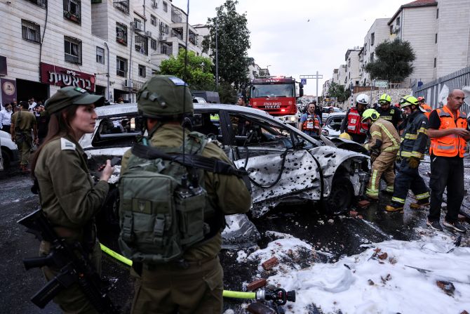 Israeli security and emergency officials respond after a rocket landed in the Israeli settlement of Beitar Ilit, in the occupied West Bank, on October 9.