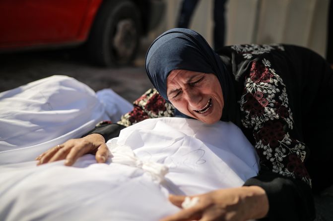 A woman mourns over a dead man at the Al-Aqsa Martyrs Hospital in Gaza City on October 18.