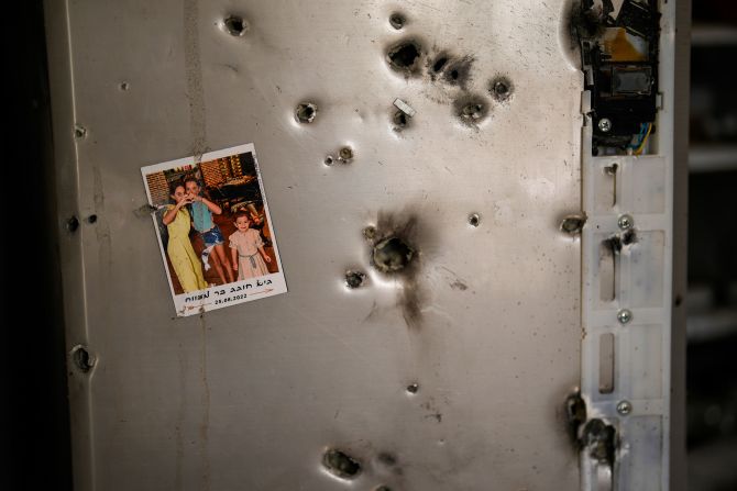 A photo hangs on a refrigerator dotted with bullet holes in a home in Kibbutz Kissufim, Israel, on October 21.