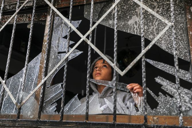 A Palestinian child looks through a broken window of a destroyed building, in Rafah, Gaza, on Wednesday, November 15.