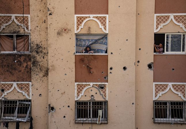 Palestinians look at destruction after an Israeli strike in Khan Younis, Gaza, on Saturday, November 18.