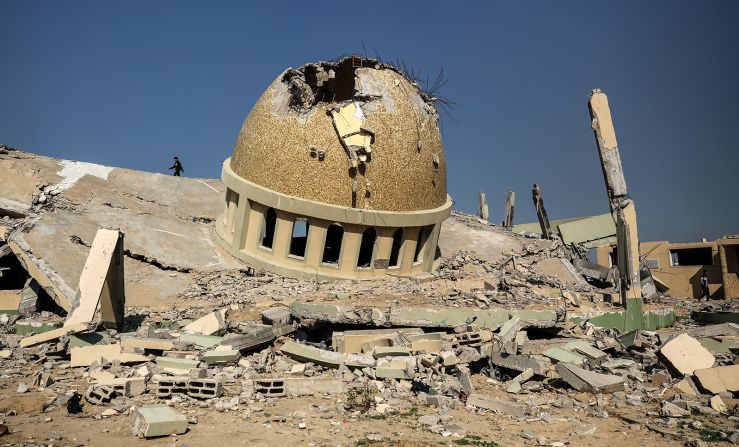 People walk through the debris of a mosque, as a temporary truce between Israel and Hamas took effect, in Khan Younis, Gaza, on November 29.