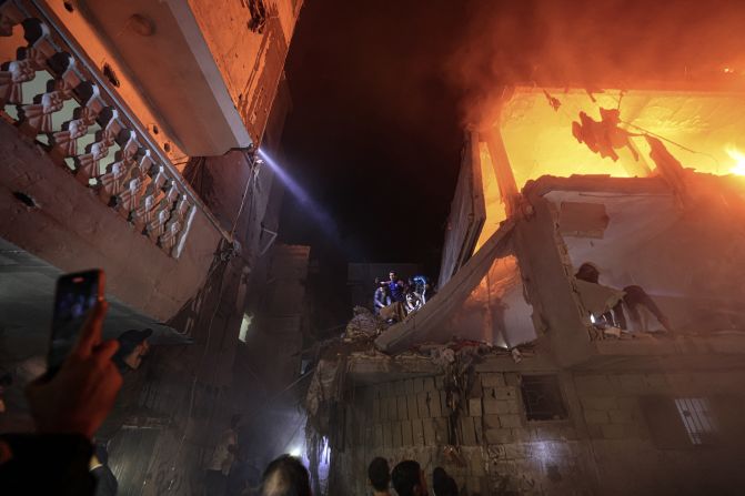 People search for victims amid the rubble of a smoldering building, following an Israeli strike in Rafah, southern Gaza, on December 6.