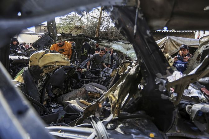 People inspect the ruins of a civilian car after it was fatally struck by an Israeli drone in Rafah, Gaza, on January 8.