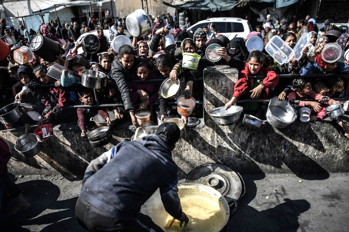 People with empty containers waiting for food to be distributed by charitable organizations in Rafah on January 25, 2024.