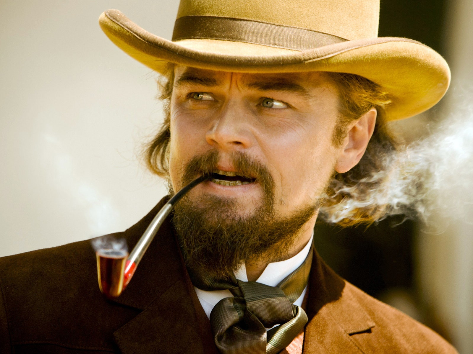 Image may contain Leonardo DiCaprio Clothing Hat Smoke Pipe Accessories Formal Wear Tie Adult Person Face and Head