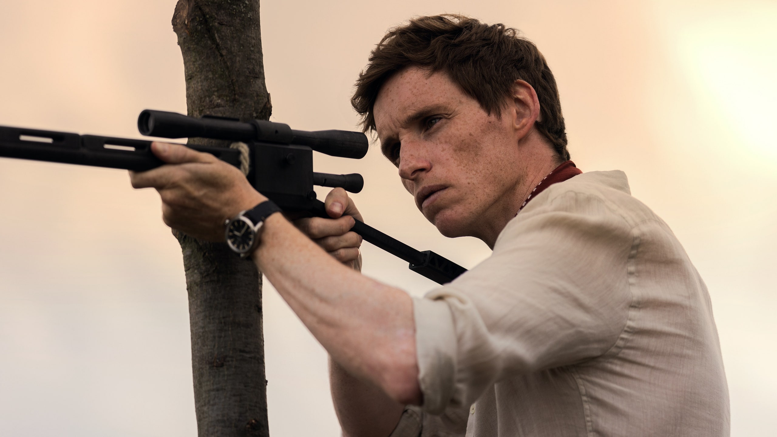 Image may contain Eddie Redmayne Firearm Weapon Adult Person Gun Shooting Rifle Accessories Jewelry and Necklace