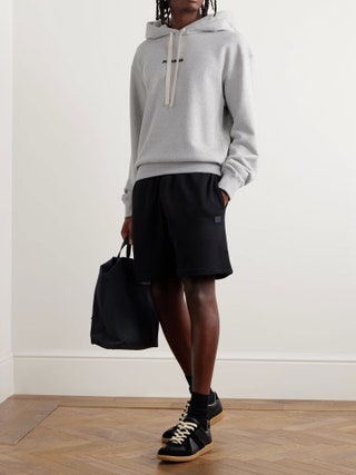 Image may contain Clothing Skirt Hoodie Knitwear Sweater Sweatshirt Shorts Footwear and Shoe