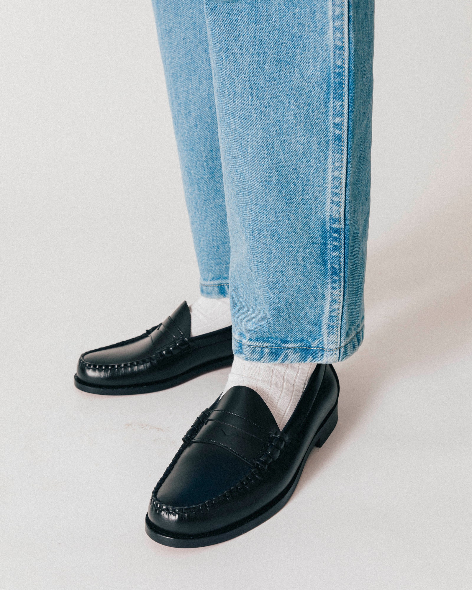 A pair of Larson Weejuns Loafers styled with white socks and blue denim