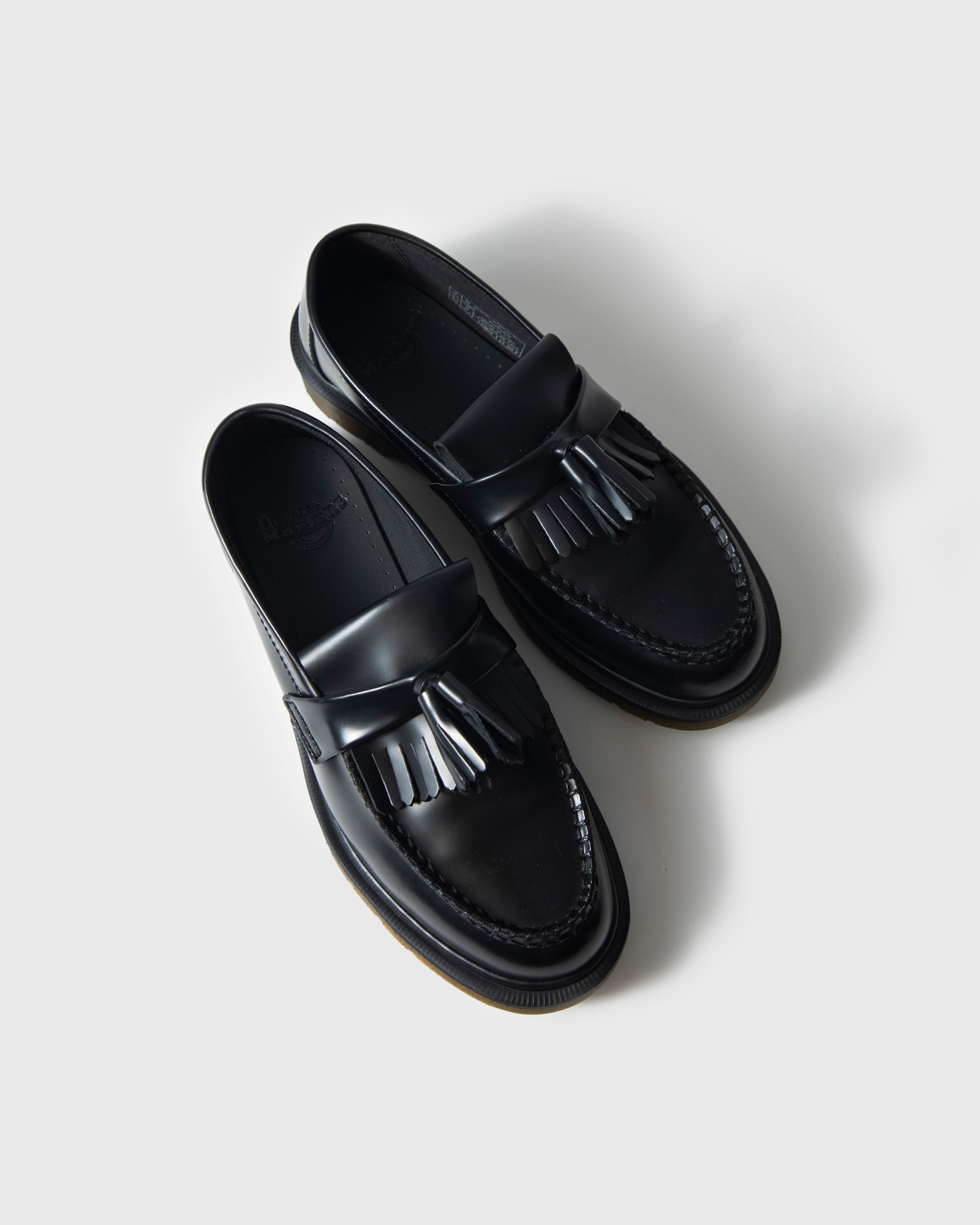 A pair of black Dr. Martens Adrian Tassel Loafers