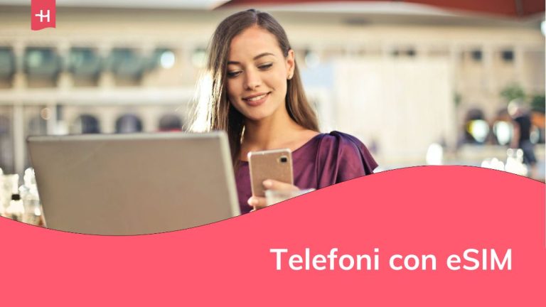 Una giovane donna sorridente davanti a un computer portatile, guardando il telefono