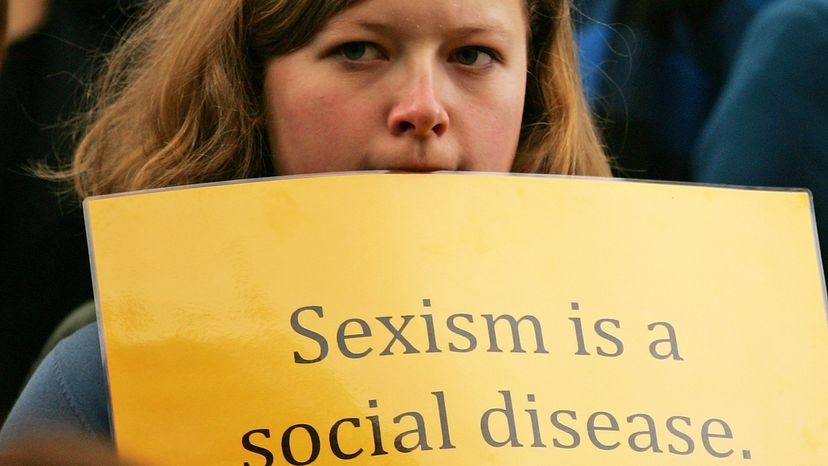 woman holding sexism sign