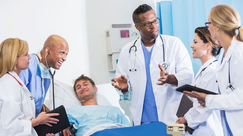 Group of medical students on rounds with doctor and patient