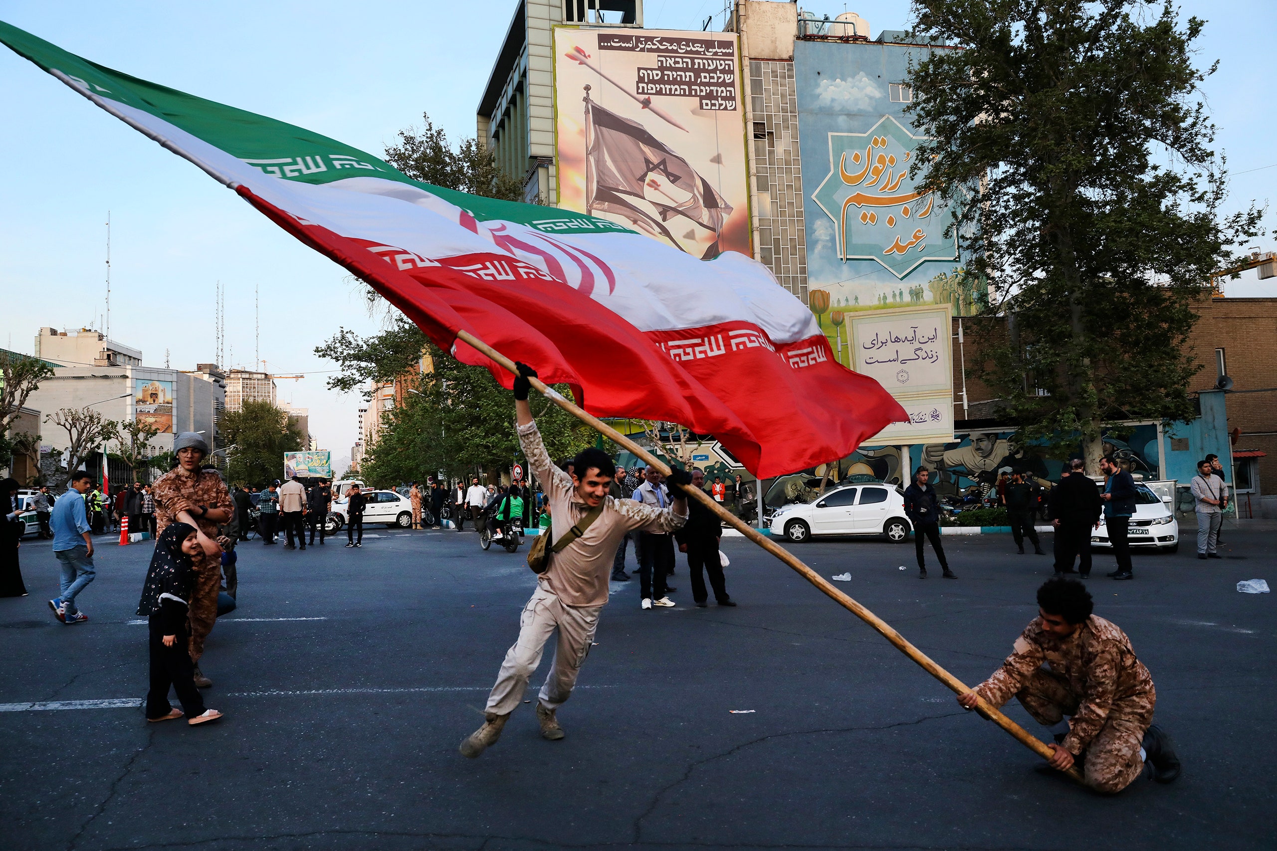 Three people with the flag of Iran.