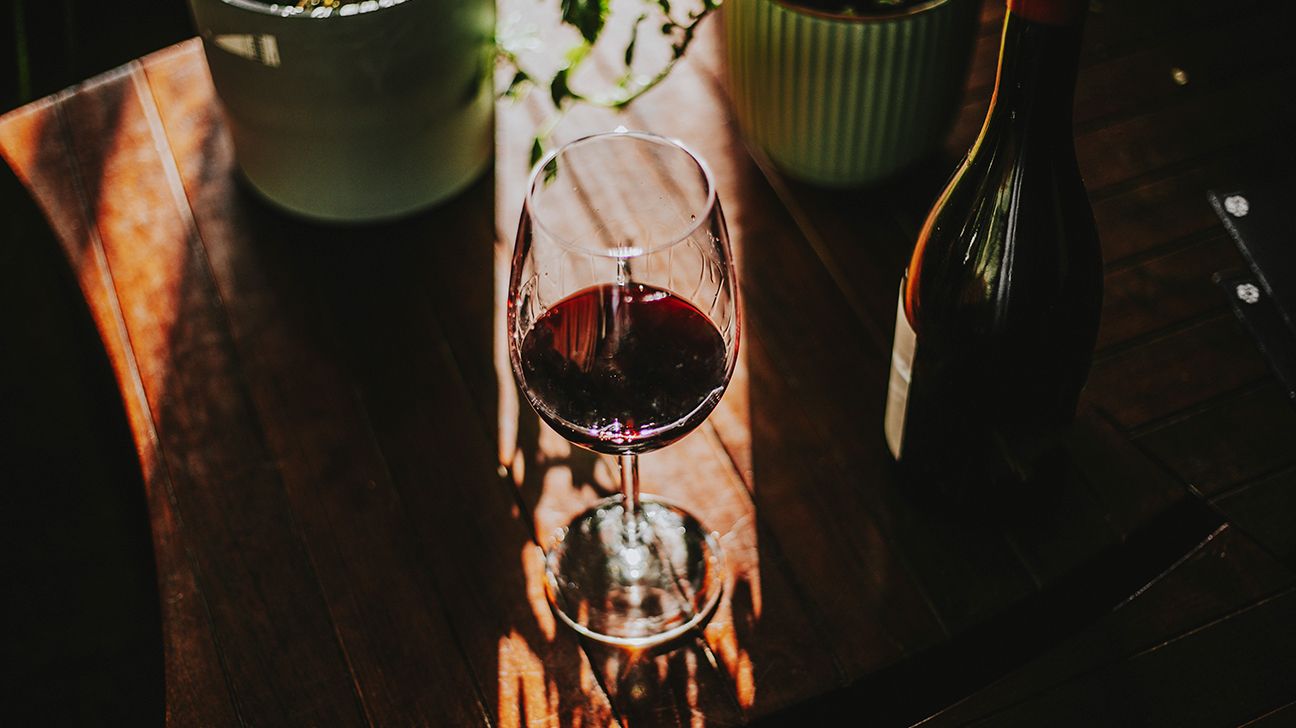 A glass of red wine on a table.