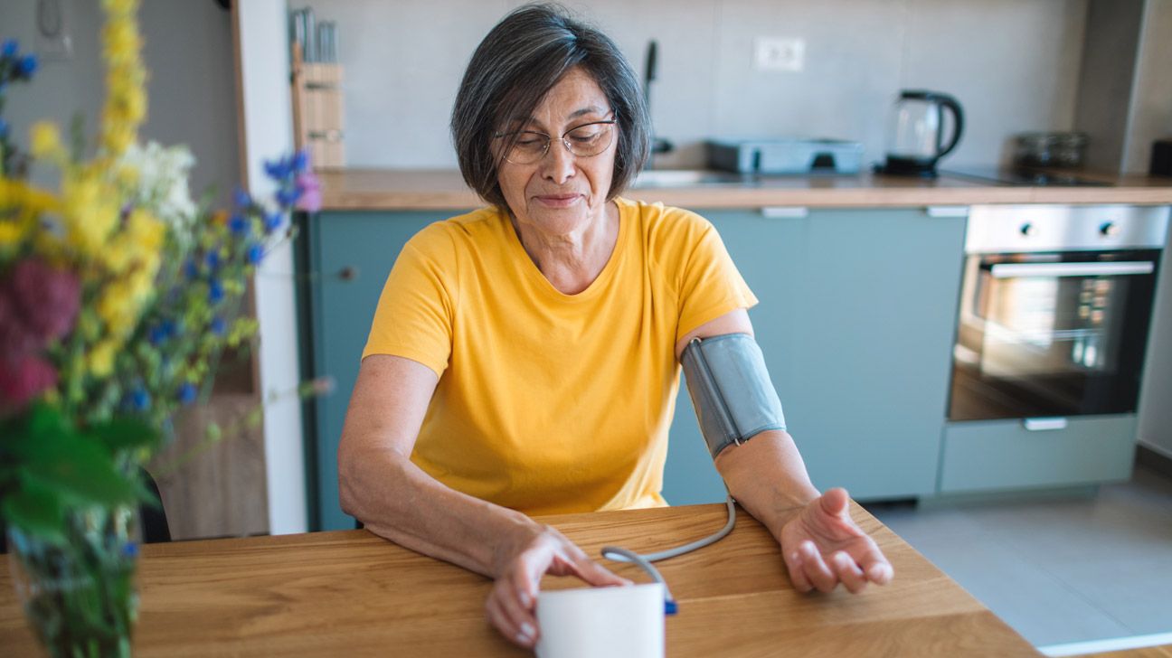 A woman checks her blood pressure at home