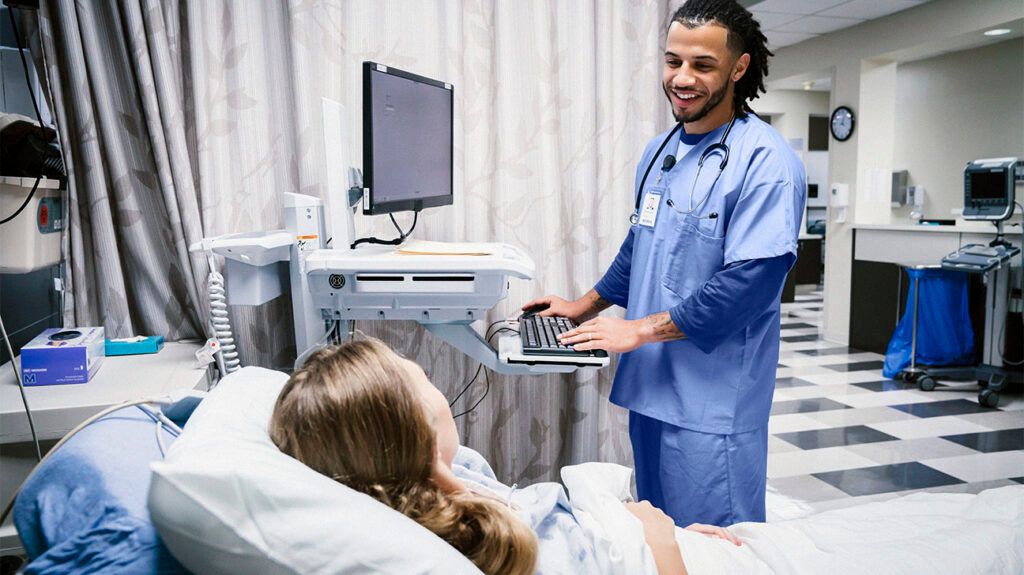 A doctor speaking with someone in a hospital bed before a thoracic outlet procedure.-2