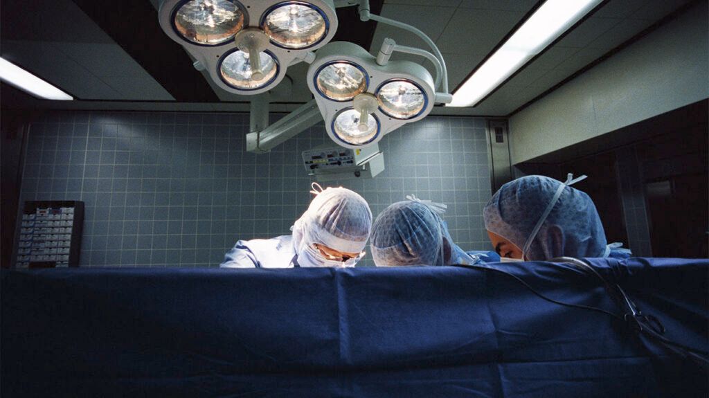 Three surgeons performing a thyroid lobectomy.